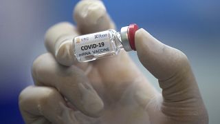 A lab technician holds a bottle containing results for COVID-19 vaccine testing at Thailand's Chulalongkorn University on May 23, 2020.