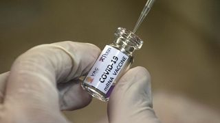 Un técnico de laboratorio extrae una porción de una candidata a la vacuna COVID-19 durante las pruebas en el Centro de Investigación de Vacunas de Chula en Tailandia.