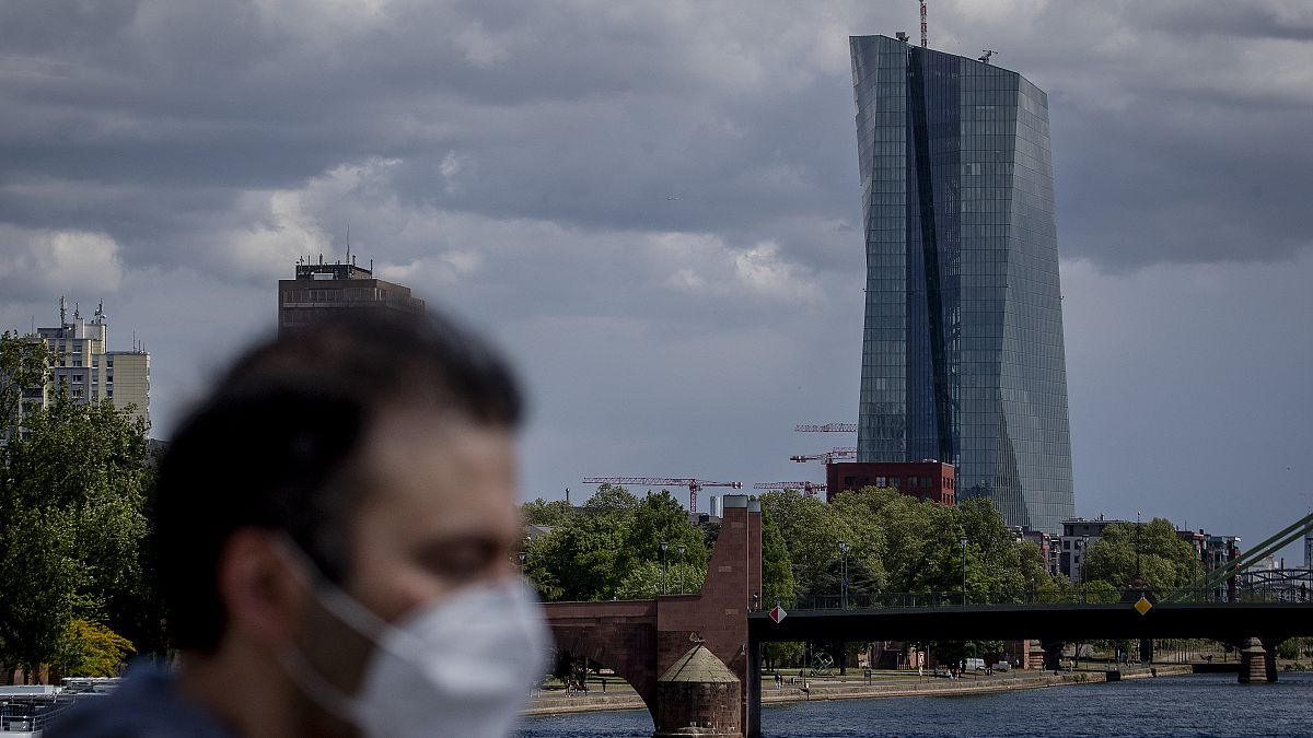 Man with mask passing by ECB Building