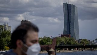 Man with mask passing by ECB Building