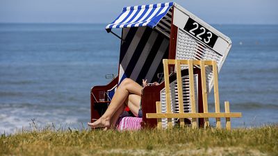 A woman is sunbathing on a beach chair by the sea in Norderney, Lower Saxony, Germany Tuesday May 26, 2020