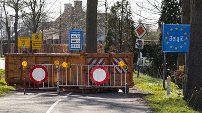 A container and barriers block a road on the Netherlands border with Belgium on March 23, 2020. 