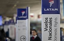 July 25, 2016, file photo, an agent of LATAM airlines stands by the counters at the airport in Santiago, Chile