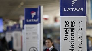 July 25, 2016, file photo, an agent of LATAM airlines stands by the counters at the airport in Santiago, Chile