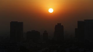 The sun rises amid smog during the dry season in Mexico City