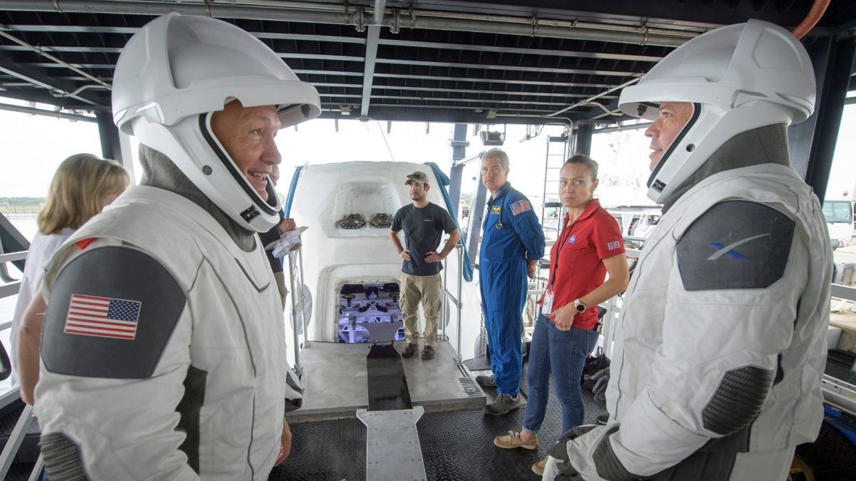 In this Aug. 13, 2019 file photo, NASA astronauts Doug Hurley, left, and Bob Behnken work with teams from NASA and SpaceX to rehearse crew extraction from SpaceX's Crew Dragon