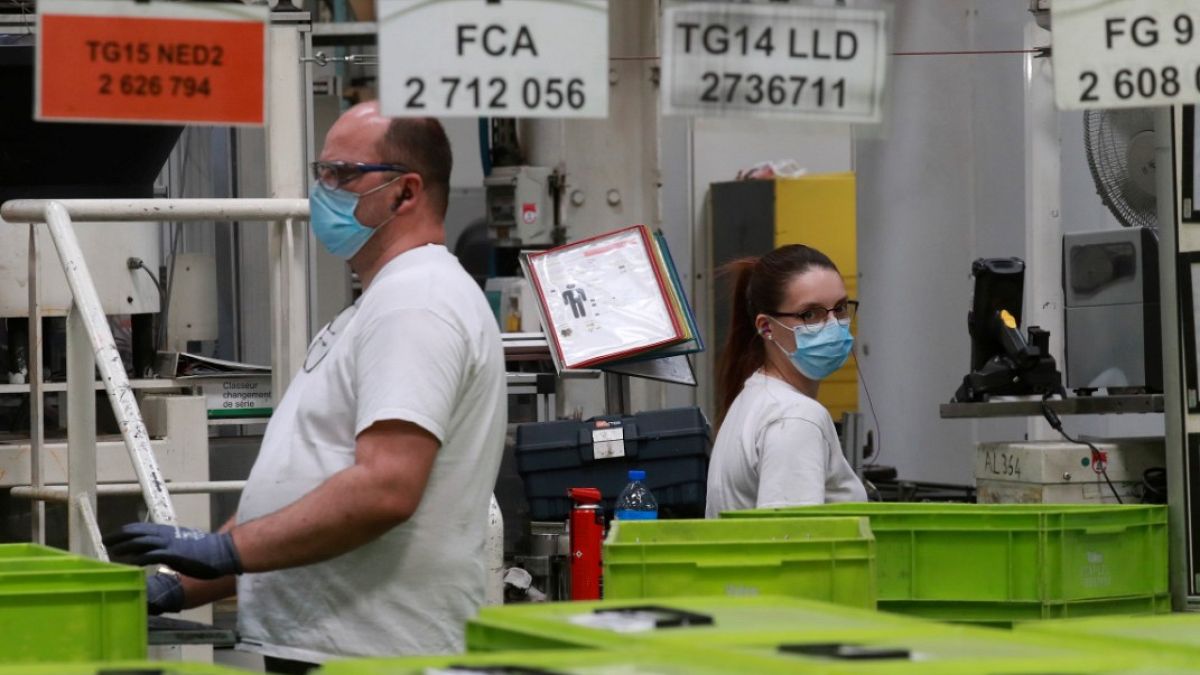 Employees work at a factory of manufacturer Valeo in Etaples, near Le Touquet, northern France on May 26, 2020 