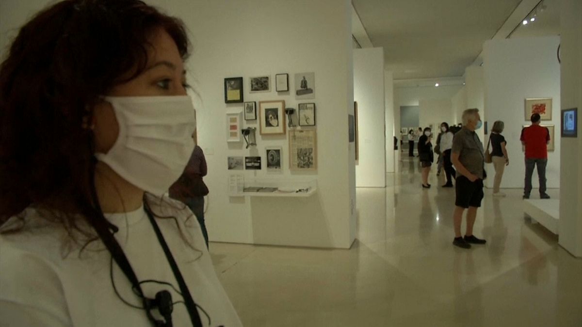 Una joven con mascarilla observa una obra de arte en un museo de Málaga