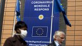 A woman wearing mouth mask, to prevent against the spread of the coronavirus, COVID-19, walks past EU headquarters in Brussels, Thursday, May 7, 2020. 