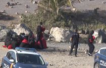 Policías nacionales reciben a un grupo de migrantes en una playa de Gran Canaria