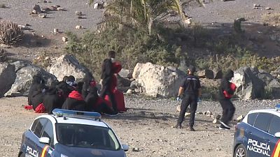 Policías nacionales reciben a un grupo de migrantes en una playa de Gran Canaria