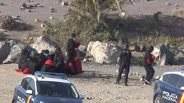 Policías nacionales reciben a un grupo de migrantes en una playa de Gran Canaria Policías nacionales reciben a un grupo de migrantes en una playa de Gran Canaria