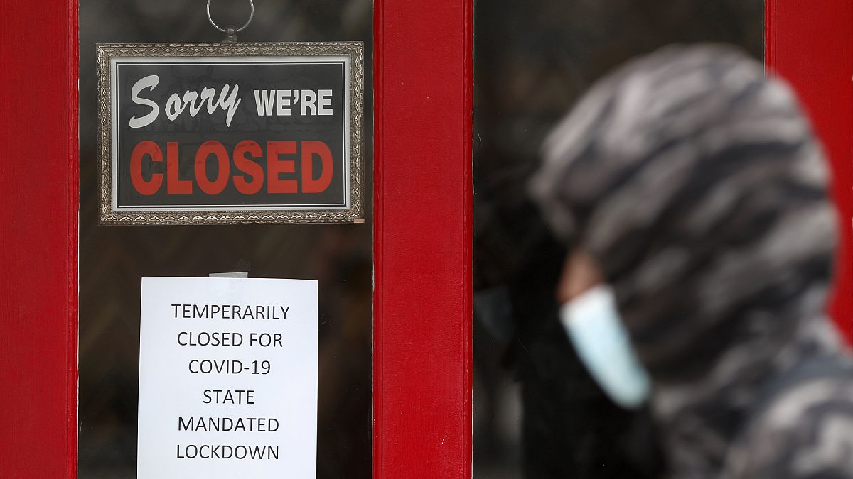 شخص يمشي امام متجر مغلق في الولايات المتحدة بسبب إجراءات الإغلاق جراء كورونا 