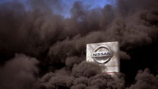 El humo se eleva sobre la fábrica de Nissan mientras los trabajadores queman neumáticos durante una protesta en Barcelona, España, el jueves 28 de mayo de 2020.