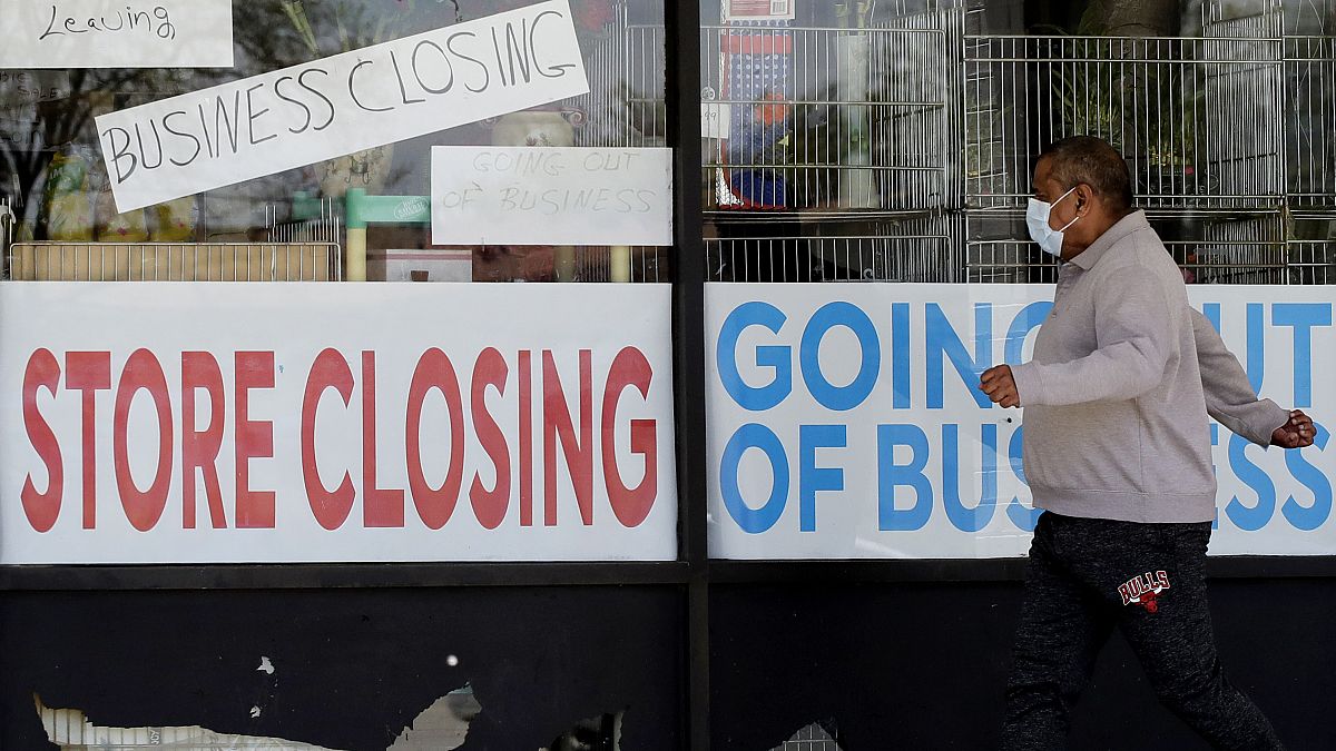A man looks at signs of a closed store due to COVID-19 in Niles, Ill., Thursday, May 21, 2020. 