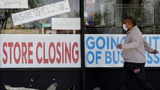 A man looks at signs of a closed store due to COVID-19 in Niles, Ill., Thursday, May 21, 2020. 