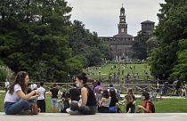 People enjoy sitting in a park in central Milan, northern Italy