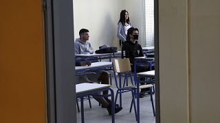 Students of the final year of high school wearing masks to prevent the spread of the coronavirus, attend a class as they are following the reopening of high schools, in Athens