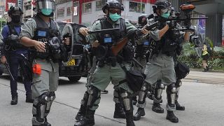 Hong Kong riot police fire tear gas as hundreds of protesters march against Beijing's national security legislation in Hong Kong, Sunday, May 24, 2020.