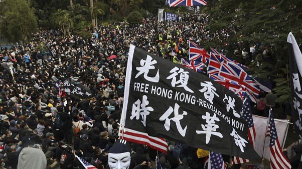 Hong Kong'daki Çin karşıtı gösteriler sırasında İngiltere ve ABD bayrakları taşıyan göstericiler Hong Kong'daki Çin karşıtı gösteriler sırasında İngiltere ve ABD bayrakları taşıyan göstericiler