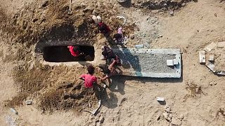 مجموعة أشخاص يحفرون قبرا في مقبرة رضوان بعدن