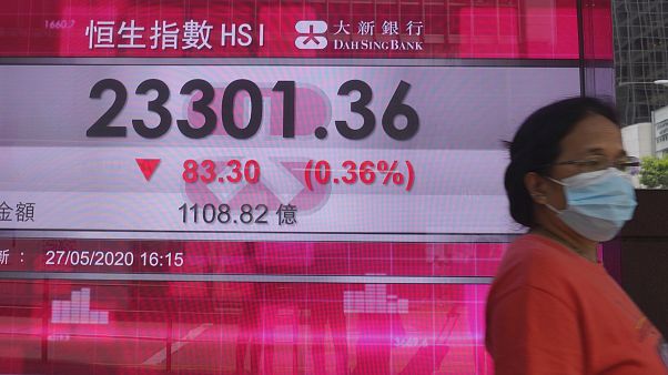 Hong Kong borsa binasının önünden geçen maskeli bir kadın Hong Kong borsa binasının önünden geçen maskeli bir kadın