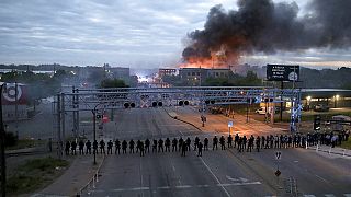 Militares e polícia patrulham as ruas de Minneapolis enquanto vários edifícios ardem, incendiados durante os protestos pela morte de George Floyd