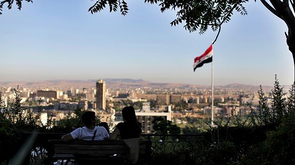 شاب ورفيقته يجلسان في حديقة عمومية مطلة على العاصمة السورية دمشق - 2019/07/24 شاب ورفيقته يجلسان في حديقة عمومية مطلة على العاصمة السورية دمشق - 2019/07/24