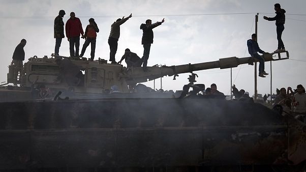 Libya'nın Bingazi kentinde tahrip edilen bir tankın üzerinde kutlama yapan halk (arşiv) Libya'nın Bingazi kentinde tahrip edilen bir tankın üzerinde kutlama yapan halk (arşiv)