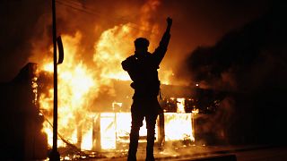 In this May 29, 2020, photo, a check-cashing business burns during protests in Minneapolis. Protests continued following the death of George Floyd