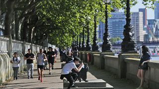 La gente disfruta del clima soleado y cálido a orillas del río Támesis en Londres, el jueves 28 de mayo de 2020, tras el alivio gradual del cierre de Covid-19.