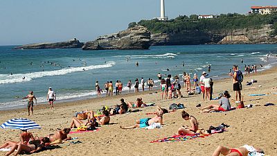 People sit on Biarritz beach, southwestern France, Saturday, May 30, 2020.