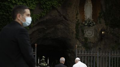 A priest wears face mask to prevent the spread of COVID-19, as Pope Francis prays during a rosary in Vatican gardens Saturday, May 30, 2020. 
