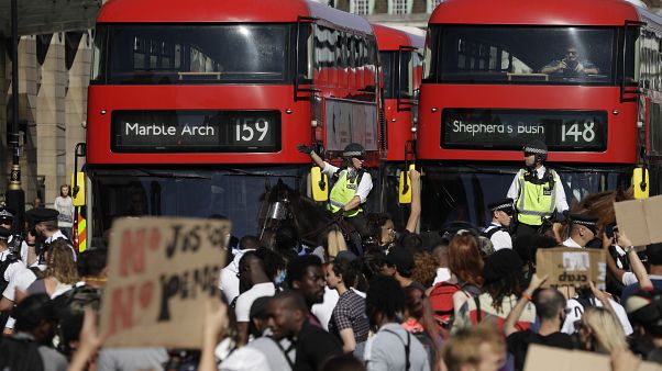 Policía a caballo frente a los manifestantes que bloquean la carretera en el centro de Londres el domingo 31 de mayo de 2020, para protestar contra el reciente asesinato de Ge Policía a caballo frente a los manifestantes que bloquean la carretera en el centro de Londres el domingo 31 de mayo de 2020, para protestar contra el reciente asesinato de Ge