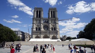 People walk on the forecourt of Notre Dame's Cathedral, in Paris, Sunday, May 31, 2020