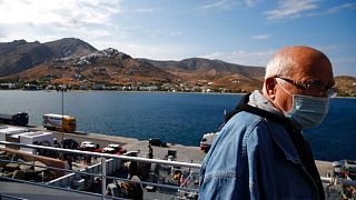 A passenger on the deck of a ferry as it approaches the Aegean Sea island of Serifos, Greece, on Tuesday, May 26, 2020.