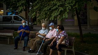 Un grupo de ancianos sentados con mascarillas en Barcelona, España
