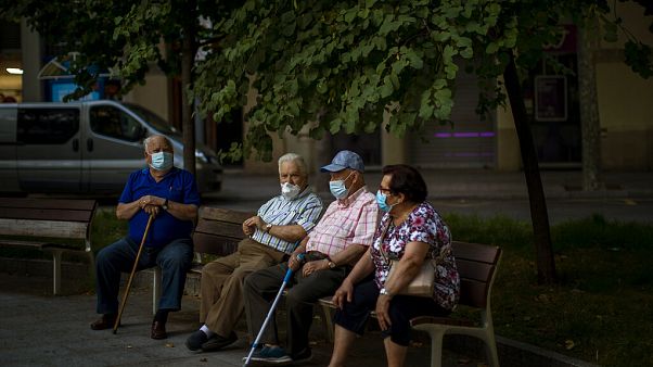 Un grupo de ancianos sentados con mascarillas en Barcelona, España Un grupo de ancianos sentados con mascarillas en Barcelona, España