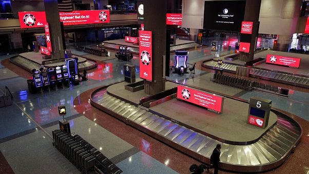 Ein Mann geht durch die Gepäckausgabe am Flughafen in Las Vegas, Freitag, 29. Mai 2020. Rot leuchten Schilder mit Hinweisen gegen Coronavirus-Infektionen. Ein Mann geht durch die Gepäckausgabe am Flughafen in Las Vegas, Freitag, 29. Mai 2020. Rot leuchten Schilder mit Hinweisen gegen Coronavirus-Infektionen.