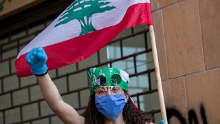 متظاهرة لبنانية ترتدي كمامة واقية كإجراء وقائي لمكافحة عدوى فيروس كورونا