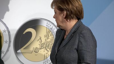 German Chancellor Angela Merkel turns to a panel showing a two Euro coin during the presentation of a special edition of the coin at the chancellery in Berlin, Germany, Thursd