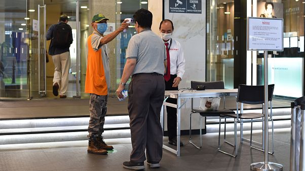 التثبت من درجة حرارة رجل عند دخوله مبنى في سنغافورة - 2020/06/02 التثبت من درجة حرارة رجل عند دخوله مبنى في سنغافورة - 2020/06/02