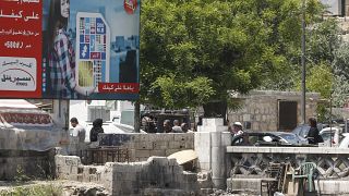 أناس يمشون في دمشق قرب لوحة إشهارية لأكبر مشغل للهواتف المحمولة في البلاد يملكها رامي مخلوف - 2020/05/11