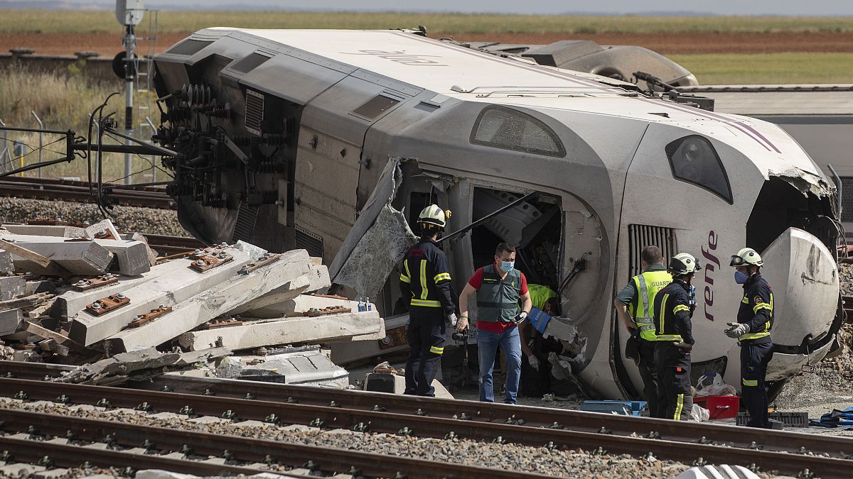 Bomberos y guardias civiles en la escena de un accidente después de que un tren de pasajeros de alta velocidad chocara con un coche en La Hiniesta