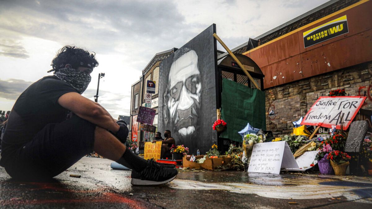 Trevor Rodriquez sits alone at the spot where Floyd died while in police custody, Tuesday June 2, 2020, in Minneapolis. 