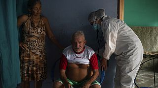 Francisco de Oliveira, 77 anos, respira fundo enquanto é examinado por um médico em Manacapuru, Amazonas