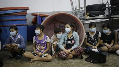 Children and teenagers to be registered by officials during a raid on a shrimp shed in Thailand. 