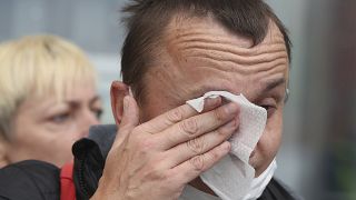 شخص يمسح عيونه بسبب غازات مسيلة للدموع في بولندا