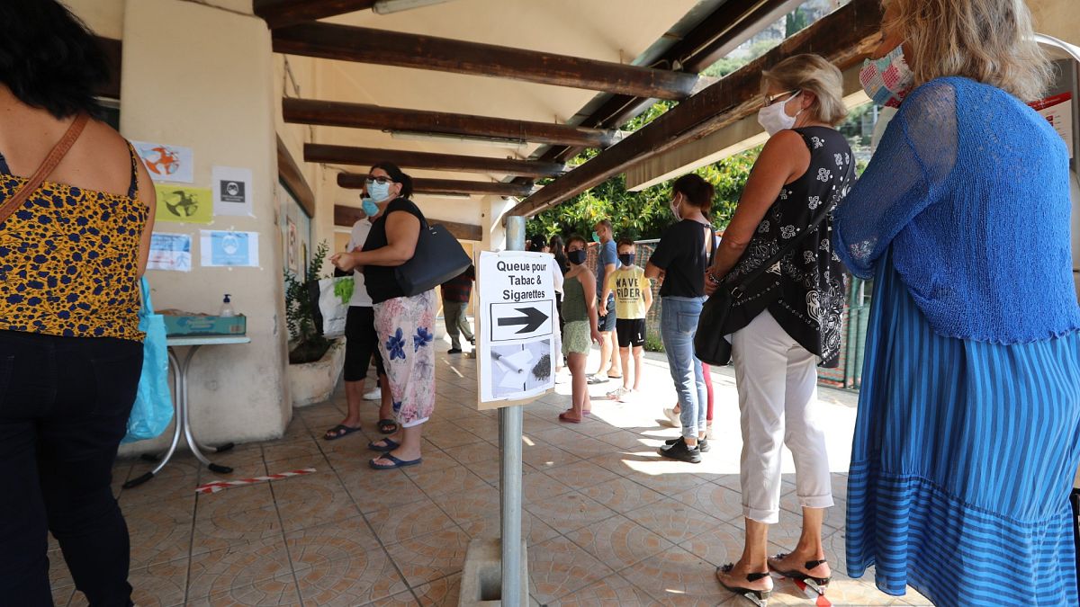Des Français font la queue devant un tabac de l'autre côté de la frontière italienne le 3 juin