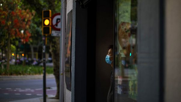Sunday, May 31, 2020 photo, a waiter wearing a face mask waits for customers in a terrace bar in Barcelona. Sunday, May 31, 2020 photo, a waiter wearing a face mask waits for customers in a terrace bar in Barcelona.